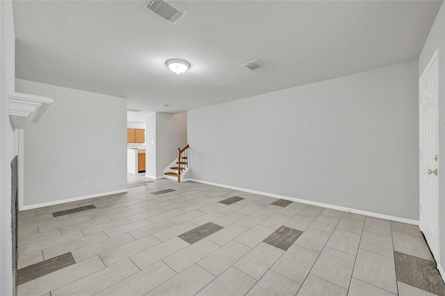 spare room with visible vents, baseboards, and stairs