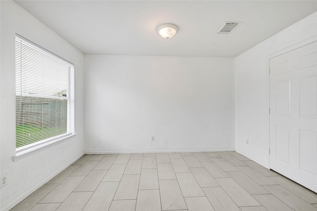 empty room with baseboards and visible vents