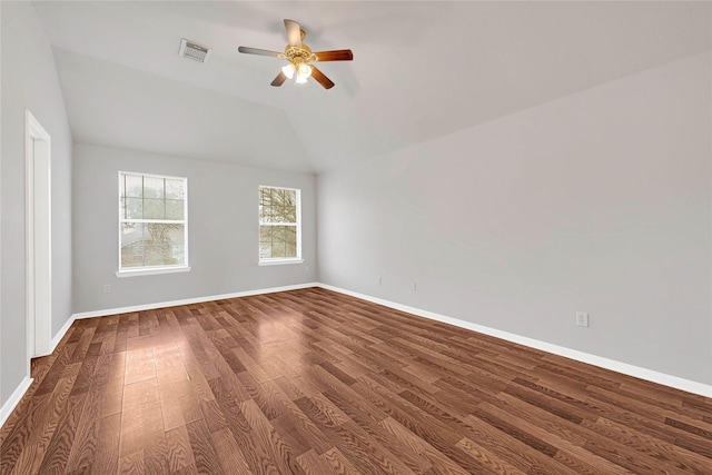 spare room with lofted ceiling, wood finished floors, visible vents, and baseboards