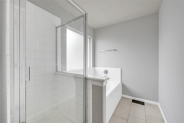 full bath with a garden tub, baseboards, tile patterned flooring, and a shower stall