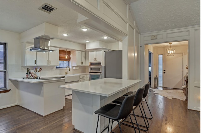 kitchen featuring white cabinets, a breakfast bar, visible vents, and light countertops