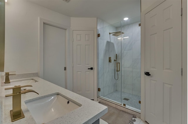 full bath with double vanity, a stall shower, and a sink