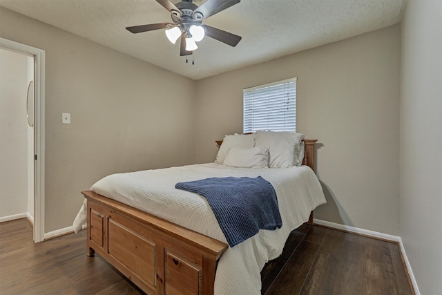 bedroom featuring dark wood-style floors, a textured ceiling, and baseboards