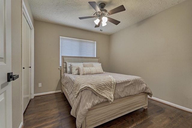 bedroom with a textured ceiling, dark wood finished floors, and baseboards