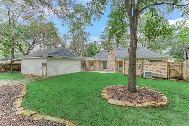 rear view of house featuring a lawn, a fenced backyard, a gate, central air condition unit, and brick siding