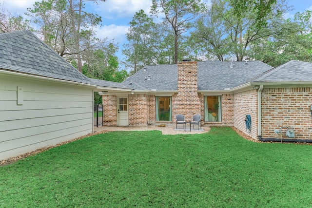 back of house featuring roof with shingles, a chimney, and brick siding