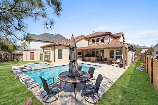 back of house featuring a yard, a bar, a patio area, and a fenced backyard