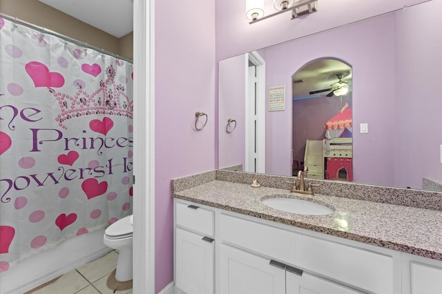 bathroom with a ceiling fan, toilet, tile patterned floors, shower / bath combination with curtain, and vanity