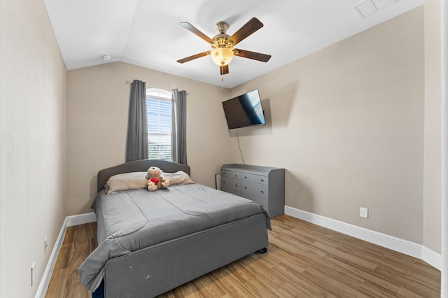 bedroom featuring lofted ceiling, baseboards, visible vents, and light wood finished floors