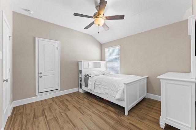 bedroom with light wood-type flooring, baseboards, and vaulted ceiling