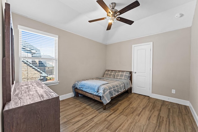 bedroom featuring ceiling fan, wood finished floors, and baseboards