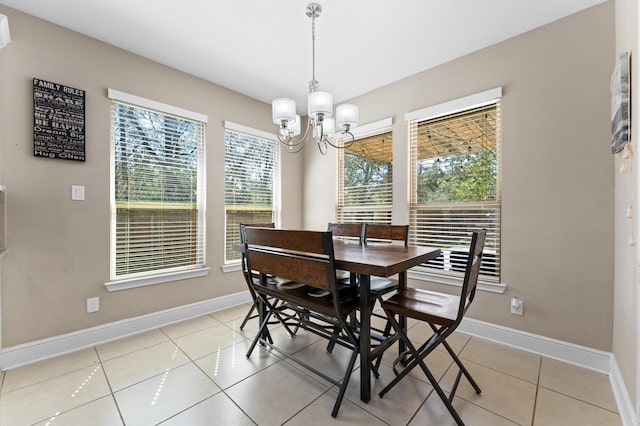 dining area with a chandelier, light tile patterned floors, and baseboards