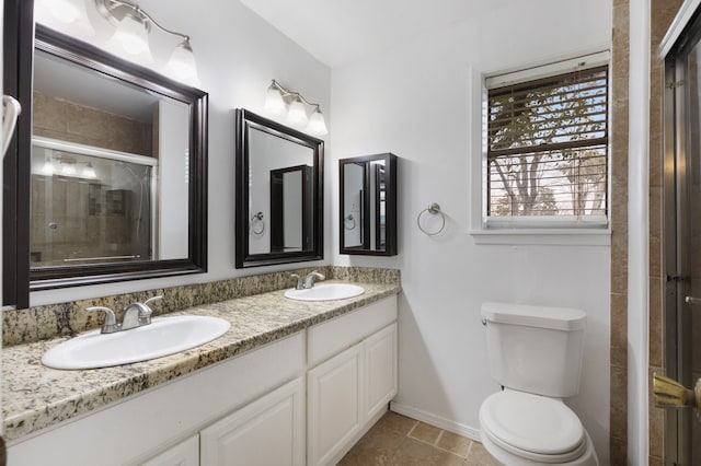 bathroom with toilet, double vanity, a tile shower, and a sink