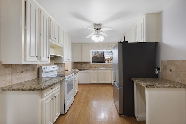 kitchen featuring white appliances, backsplash, and white cabinets