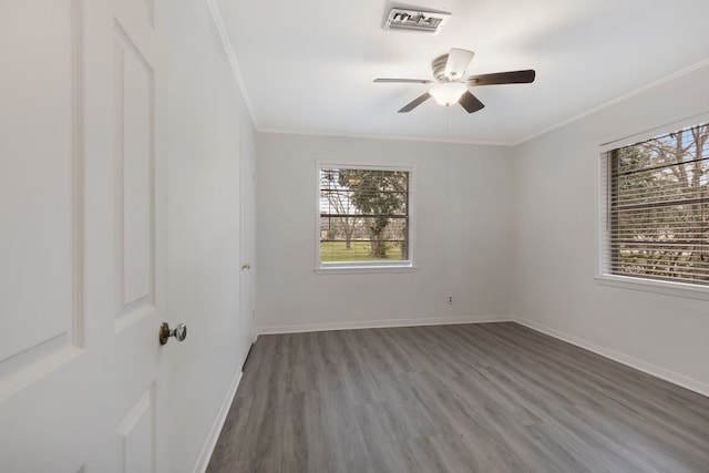 unfurnished room with ornamental molding, visible vents, baseboards, and wood finished floors