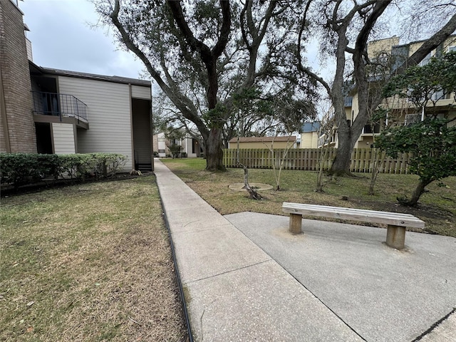 view of property's community with fence and a yard