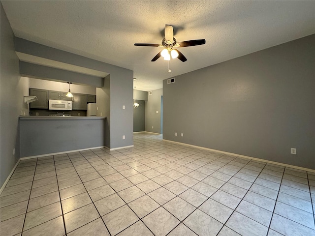 unfurnished living room featuring baseboards, ceiling fan, visible vents, and a textured ceiling