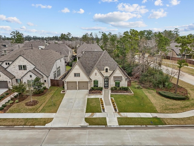 view of front of house with stone siding, a residential view, concrete driveway, and a front lawn