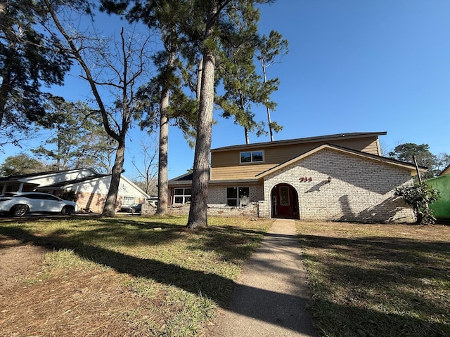 view of front of home with brick siding and a front lawn