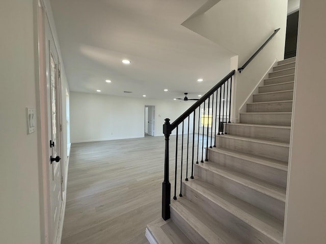 stairs with recessed lighting, ceiling fan, baseboards, and wood finished floors