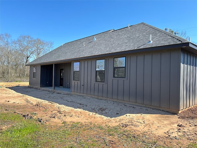 back of house featuring a shingled roof and board and batten siding