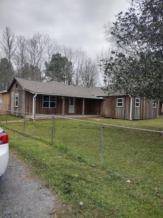 view of front of property with a fenced front yard, a front yard, and board and batten siding