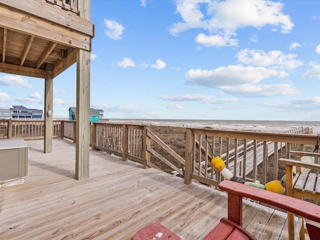 wooden deck with a view of the beach and a water view