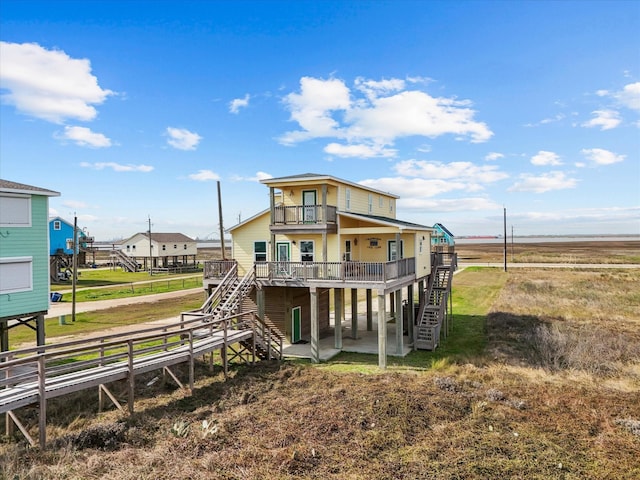 back of house with a patio area, driveway, a balcony, and stairs