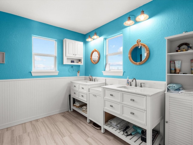 full bath with wainscoting, plenty of natural light, and vanity