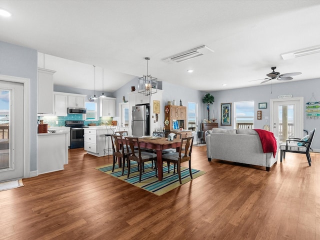 dining area featuring a ceiling fan, a wealth of natural light, visible vents, and wood finished floors