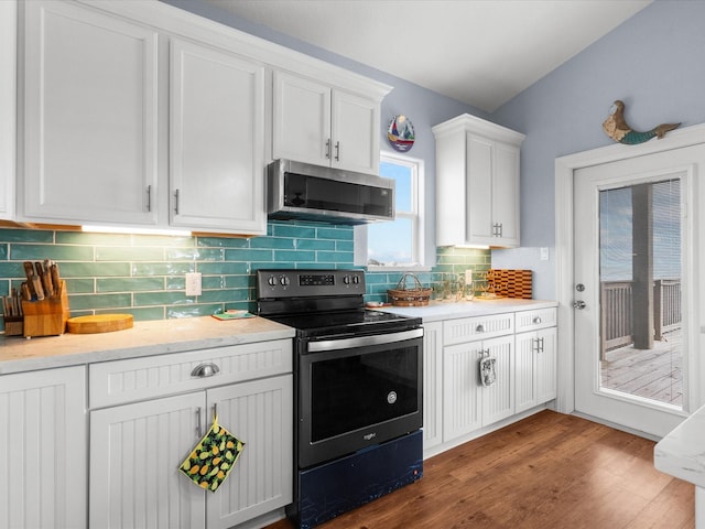 kitchen featuring wood finished floors, white cabinetry, light countertops, appliances with stainless steel finishes, and decorative backsplash