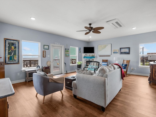 living area featuring baseboards, wood finished floors, visible vents, and recessed lighting