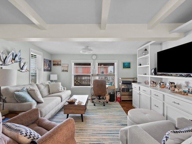 living area with beamed ceiling and wood finished floors