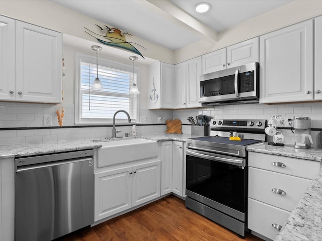 kitchen featuring white cabinetry, appliances with stainless steel finishes, pendant lighting, and a sink