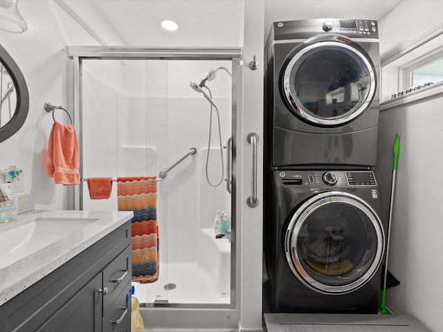 clothes washing area featuring laundry area, a sink, and stacked washing maching and dryer