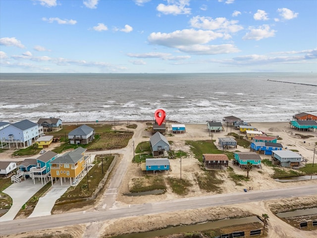 aerial view featuring a view of the beach, a water view, and a residential view