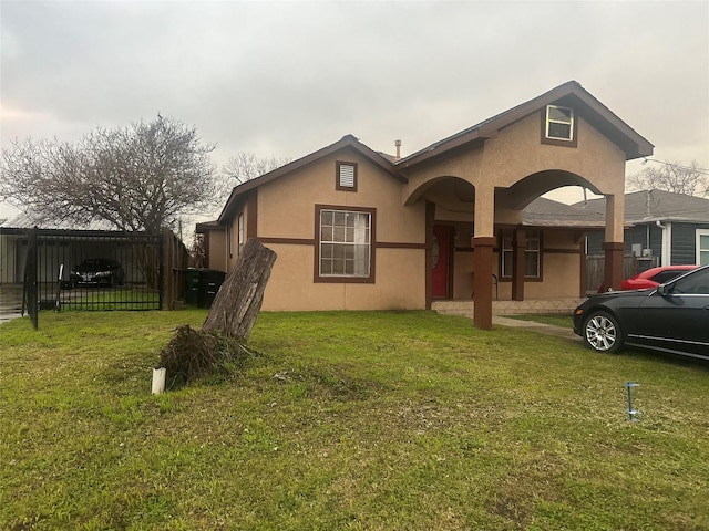 view of front of property featuring fence, a front lawn, and stucco siding