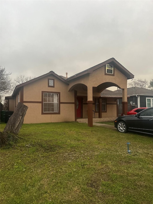 view of front of home with a front yard and stucco siding