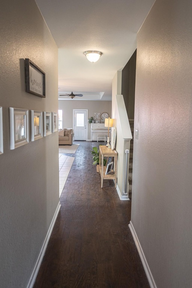 hallway with stairway, baseboards, and dark wood-style flooring