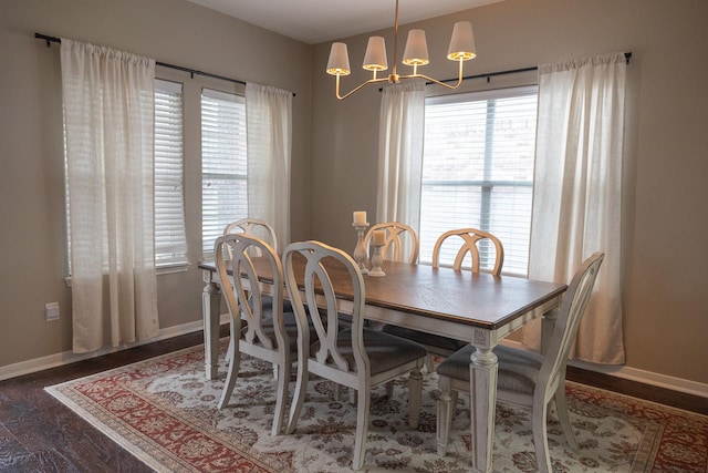 dining room featuring baseboards, dark wood-type flooring, and a notable chandelier