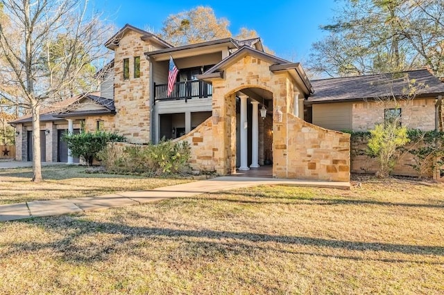 view of front of home with stone siding, a balcony, and a front lawn