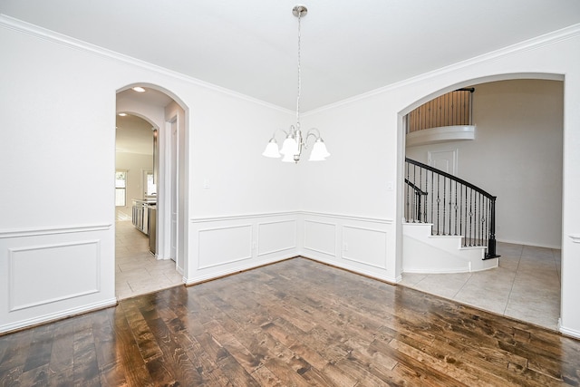 unfurnished dining area featuring stairway, ornamental molding, and wood finished floors