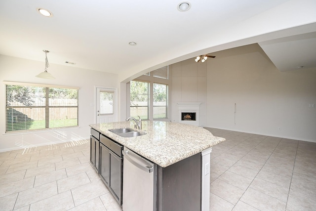 kitchen featuring an island with sink, open floor plan, decorative light fixtures, a sink, and stainless steel dishwasher