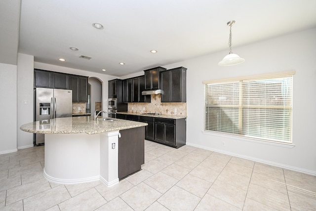 kitchen featuring a center island with sink, visible vents, appliances with stainless steel finishes, a sink, and under cabinet range hood