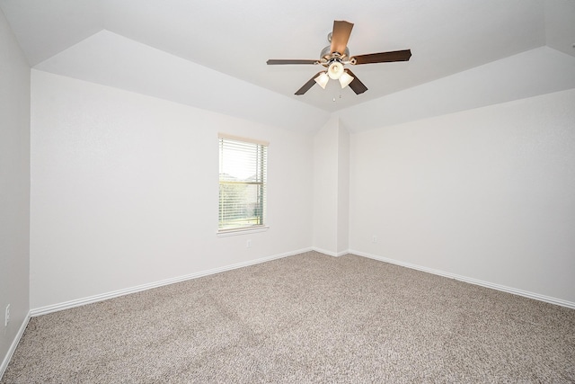 empty room featuring carpet floors, ceiling fan, baseboards, and vaulted ceiling