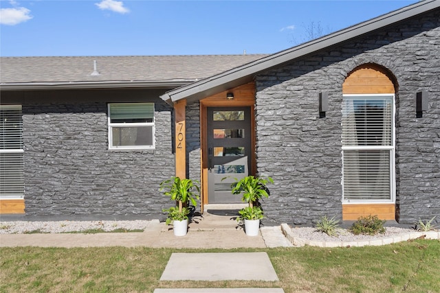 entrance to property with roof with shingles