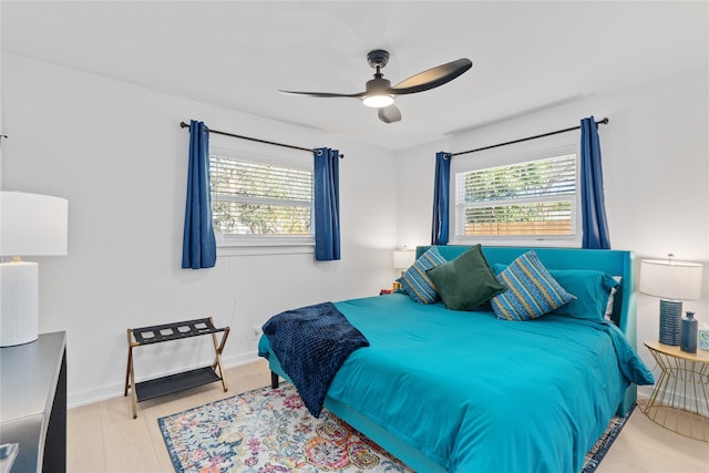 bedroom featuring multiple windows, a ceiling fan, and baseboards