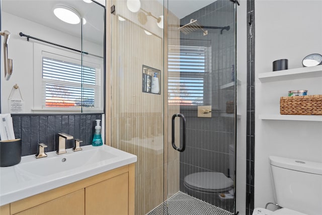 full bathroom with a stall shower, vanity, and toilet