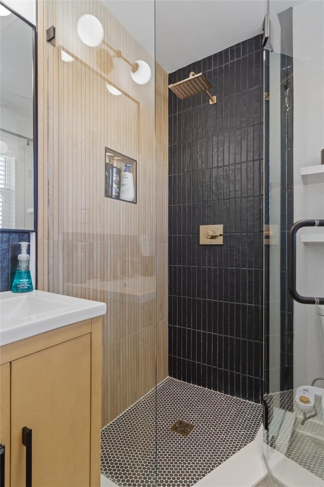 bathroom featuring tiled shower and vanity