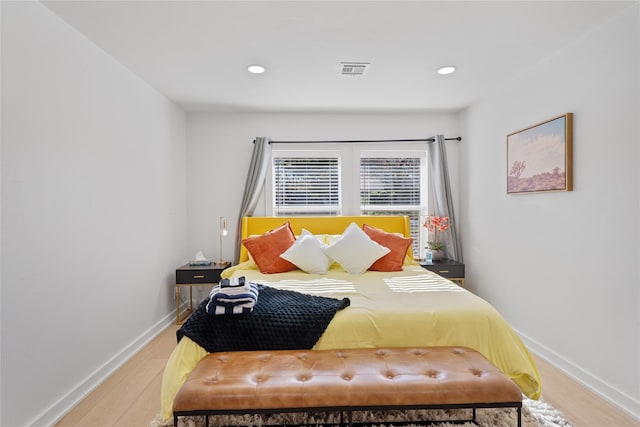 bedroom featuring visible vents, baseboards, wood finished floors, and recessed lighting